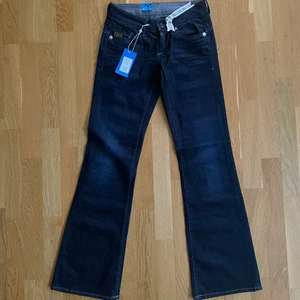 Lågmidjade G-Star Raw jeans - Supersnygga mörkblå lågmidjade G-Star Raw jeans med bootcut. Köpta från Sellpy, men var tyvärr små för mig. Helt oanvända. Midjemått: 76 cm. Frakt tillkommer.