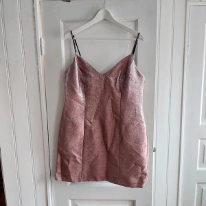 Partyklänning från Topshop - HELT OANVÄND rosaglittrig partyklänning med smala axelband (strassbeklädda) i miniform. Ingen stretch och liten i storleken 