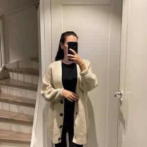 Beige kofta - Stickad Beige längre kofta med jättefina knappar! Lite Oversize. Koftan är aldrig använd. Inga skavanker!