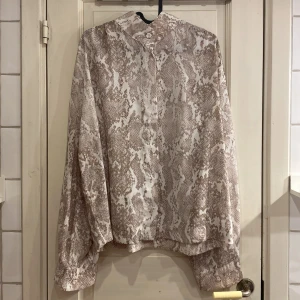 Blus med ormmotiv - Blus från Lindex med ormmotiv, bra skick, 100% polyester. Pris kan diskuteras