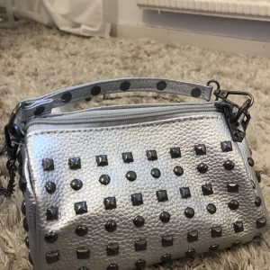 Silver väska med nitar - Denna väska är köpt på Shein och aldrig andvänd så fint skick!