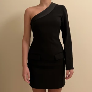 Zara klänning  - Svart klänning från zara i kostym och siden material. Två ”fickor” fram. Storlek S