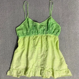 Grön cami topp - Jättesöt grön cami topp, med knappar som går att knäppa på framsidan.  I bra skick och storlek 38/M!!🍀💚💛