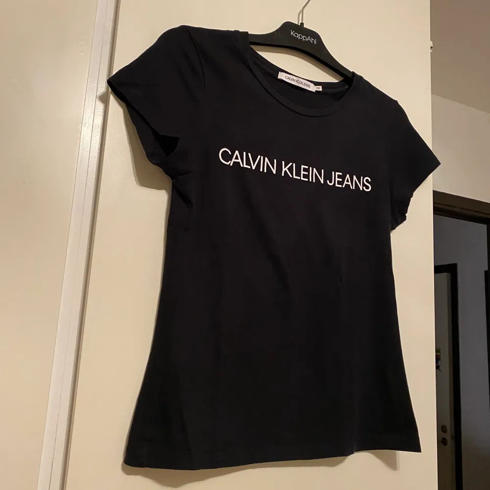En svart t-shirt med vitt tryck på brösten från Calvin Klein. Enbart använd vid att tillfälle. . T-shirts.