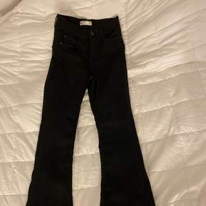 Svarta utsvängda jeans med slits från Gina Tricot, aldrig använda. Säljer pga för små