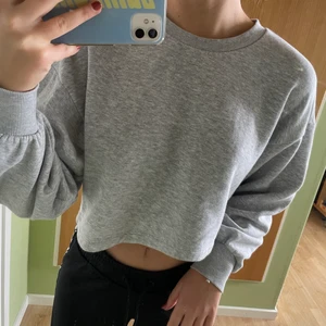 Grå sweatshirt från Gina tricot - En kort, klassisk grå sweatshirt från Gina tricot i storlek XS. Jättemjukt och skönt material inne och säljer då jag inte har någon användning för den. Köparen står för eventuell frakt!