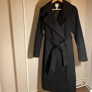 Säljer denna fina svarta kappa från Hm i storlek 38 (M) sitter jättefint på mig som endast är 1,60cm lång. Endast använd 1 vinter, den är i fint skick. Inga skador. Inköptes 2021 för 499kr. Ps köparen står för frakten!