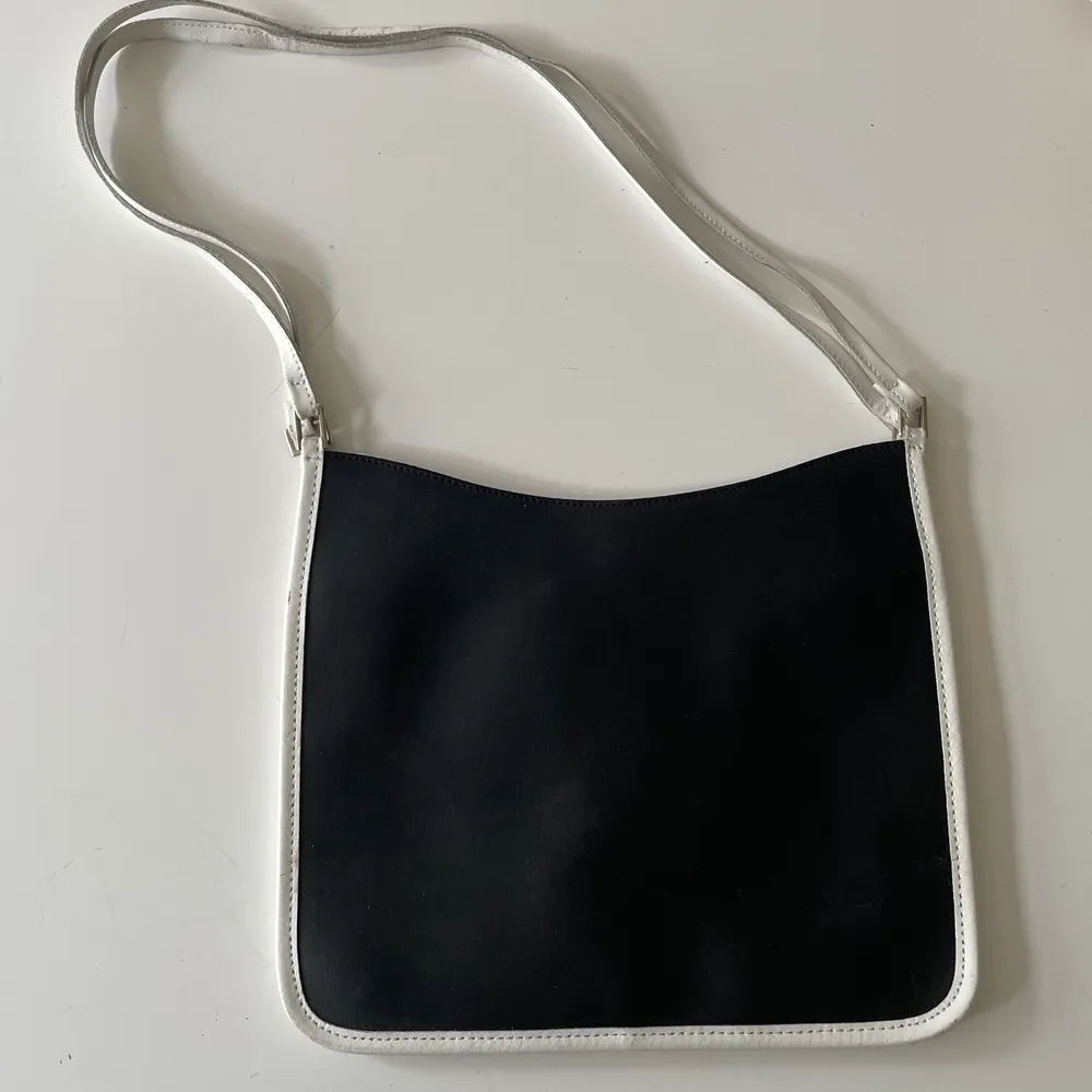 Platt svart handväska med vita och silvriga detaljer. Köpt secondhand men aldrig använt, superfint skick! 🃏. Väskor.
