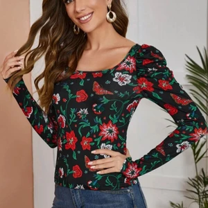 Tröja med blommor - Svart långärmad tröja i stretchigt material, röda och gröna blommor och blad i tyget. Liten puffärm. Storlek S och i nyskick. 50 kr plus ev frakt 🖤 Skriv för egna bilder!