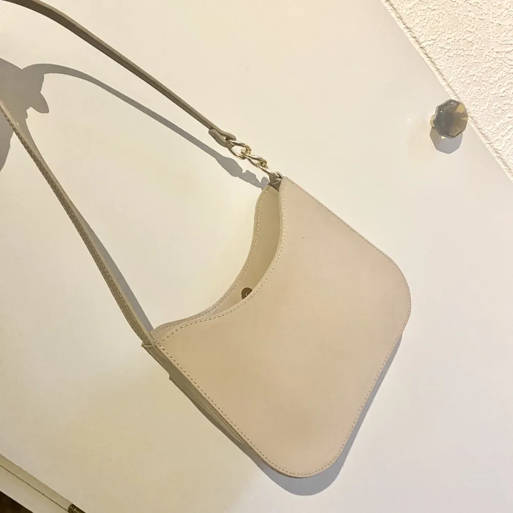 Helt ny handväska från ASOS som aldrig använts. I nyskick! Lite lackigt material i ljusbeige/krämfärg. ❣️. Accessoarer.