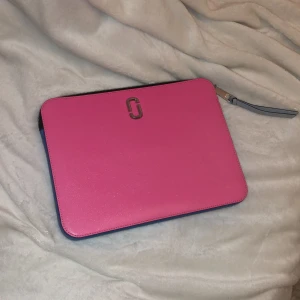 Datorskal - Säljer mitt fina datorskal från Marc Jacobs! Den är i en stark rosa färg som ni kan se på bilden med marinblåa kanter (bild 2)💞På baksidan finns en liten ficka plats för exempelvis bankkort! Skulle säga att den är helt i nyskick! 