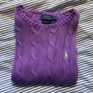 Stickad tröja från Ralph Lauren i storlek S - En lila, stickad tröja från Polo Ralph Lauren. Tröjan har några ”lösa” trådar på insidan av halsen, skickar gärna bilder om önskas. 