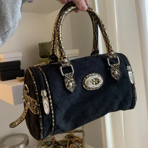 Coach väska med gulddetaljer - Sjukt fin väska, svart med gulddetaljer. Använd ett fåtal gånger och inga defekter💕