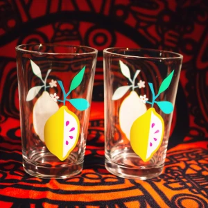 Dricksglas med citroner  - Två söta dricksglas med tryck av citroner på fram- och baksida. I fint skick då de knappt har använts. 🍋💛  1 för 10 eller båda för 15.  11 cm höga och 7 cm i diameter.