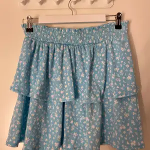 En kort blommig kjol från hm i storlek m.