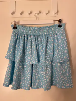 En kort blommig kjol från hm i storlek m.