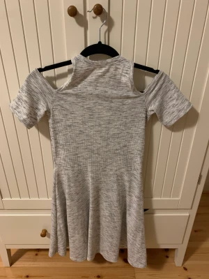 Klänning  - Grå klänning med offshoulder armar och vanliga axelband. Storlek S 
