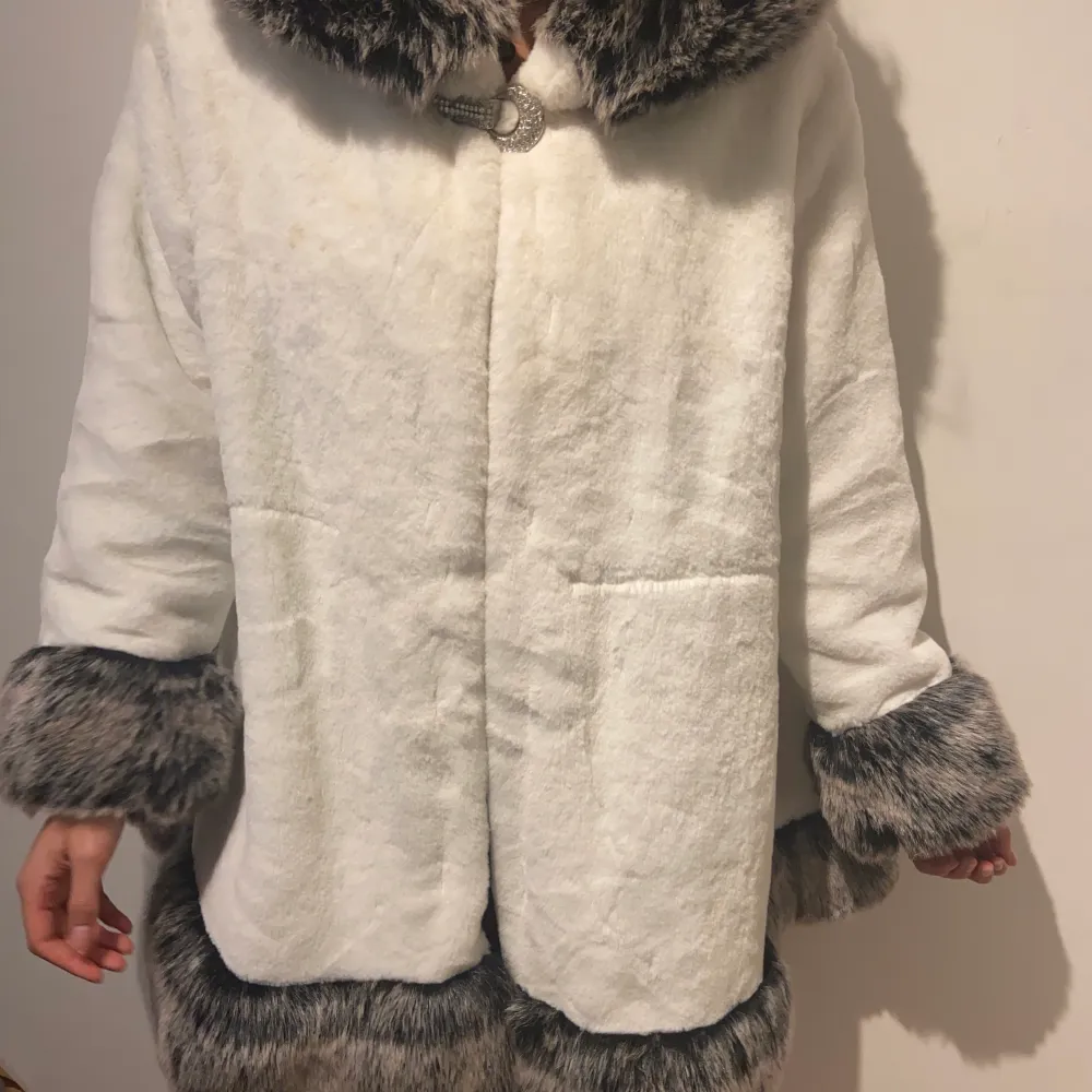 Vit kappa med fake päls. Spänne av stenar. Varm men inte superduper varm. Inga fläckar eller hål. Väldigt skönt material. Uppskattas till large. Skriv vid funderingar! :p. Takit.