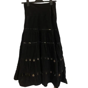 Manchester-kjol - Så fin kjol i Manchester. Detaljerna på framsidan är i paljetter och typ mynt. Strl står som L, men passar mig som brukar ha M (om man vill att den ska sitta lite lågmidjat.