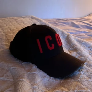 Icon Dsquared2 keps - Icon Dsquared2 keps i svart och röd färg. Färgen är ytterst lite solblekt men annars är kvaliten bra. Nypris 1300 kr men med tanke på det solblekta blir mitt pris 500 kr. Kvitto finns inte