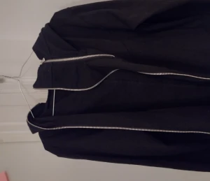 Techwesr hoodie - En svart hoodie med olika zippers och former som ser techwesr inspirerad ut när den är på.