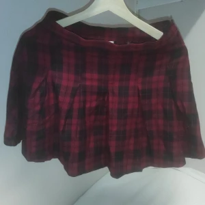 Rutig tenniskjol - Svart och röd rutig kjol . Storlek 36 