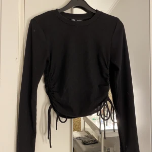 Svart tröja - En jättefin svart långärmad tröja med drag-skor på sidorna. Den går och göra både längre och kortare vilket är superbra! Den passar både xs och s. Jag har i vanliga fall xs och den sitter bra på mej! I nyskick, pris kan diskuteras 