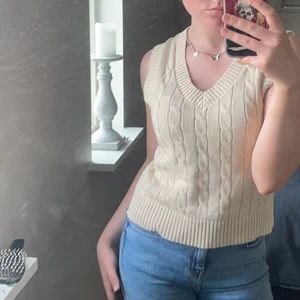 Stickad beige väst från Monki - Oanvänd stickad fin beige väst från Monki med mönster över framsidan. Den är cuttad i varsin sida och sitter väldigt snyggt, samt är mycket bekväm.