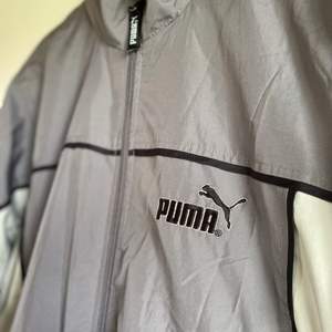 En tunnare jacka från märket Puma i en fin grå färg. Köpt på second hand. Stl.168, sitter som stl. S.