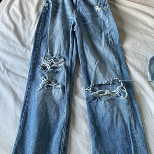 Jeans  - Jeans med hål där bak och fram och går att ha skärp till. Storlek:32