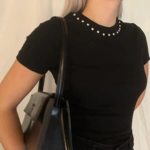 T-shirt med detalj - Fin t-shirt med söta stenar i halsen. 