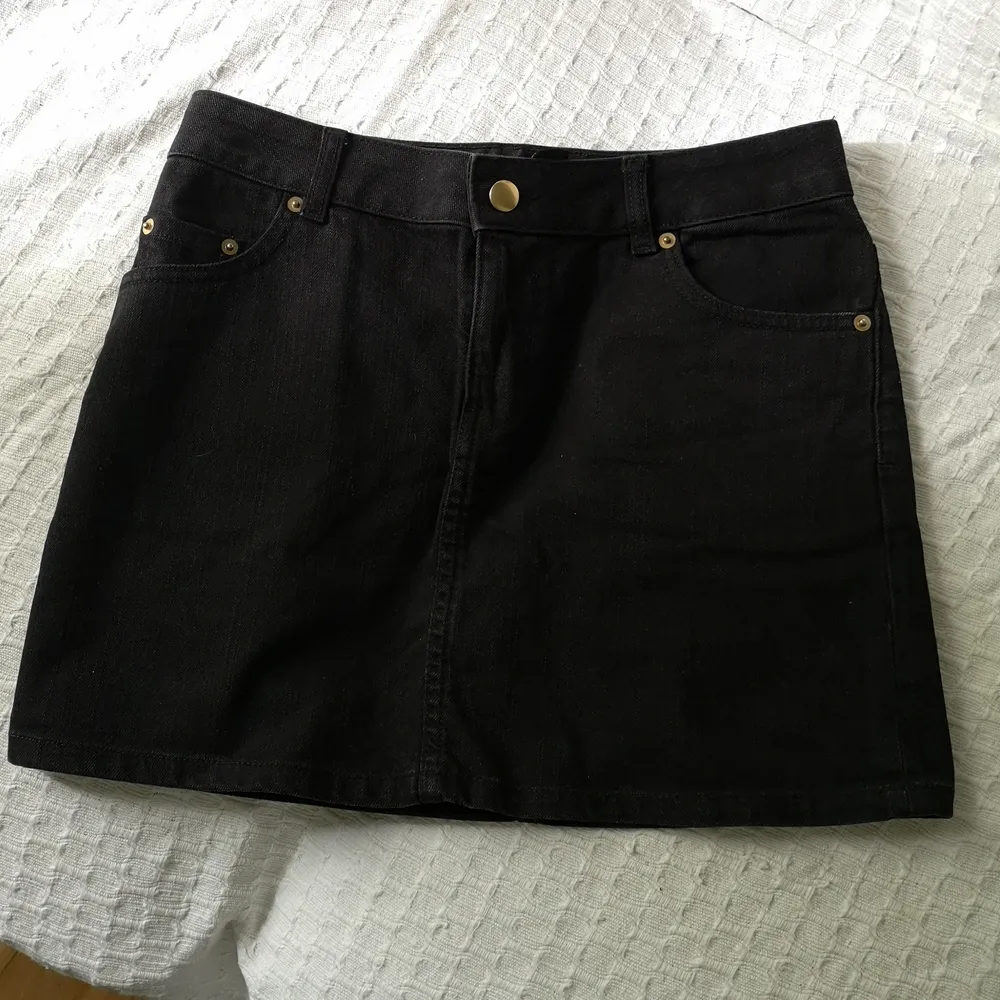 Söt svart jeanskjol med guldiga detaljer från H&M. Har 4 fickor. 74cm i midjan och 35cm lång. Tröjan är också till salu, se i profil. . Kjolar.