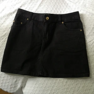 H&M jeanskjol strl 34 - Söt svart jeanskjol med guldiga detaljer från H&M. Har 4 fickor. 74cm i midjan och 35cm lång. Tröjan är också till salu, se i profil. 