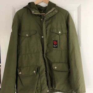 Fjällräven dunjacka - Gammal modell fjällräven dunjacka. ”Fläck” på kapuschong, se bild. Hänger är sönder, se bild. Gott skick. 