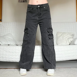 Cargo Jeans - Säljer dessa coola grå-svarta jeans med fickor i storlek Large! 84cm midja och 72cm innerbenslängd❤️ Jag på bilderna är 172cm lång och brukar bära storlek 38/W28/S-M💕