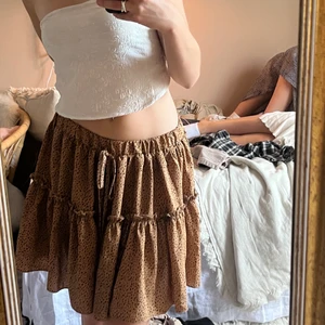 Kort brun volangkjol  - Jättesöt brun kjol med prickar och lite volang i jättebra skick💕 Köpt från shein för ett år sedan men tyvärr inte använts sen dess, i storlek S och är stor i storleken så passar nog bra på en M🥰 Köparen står för frakt!