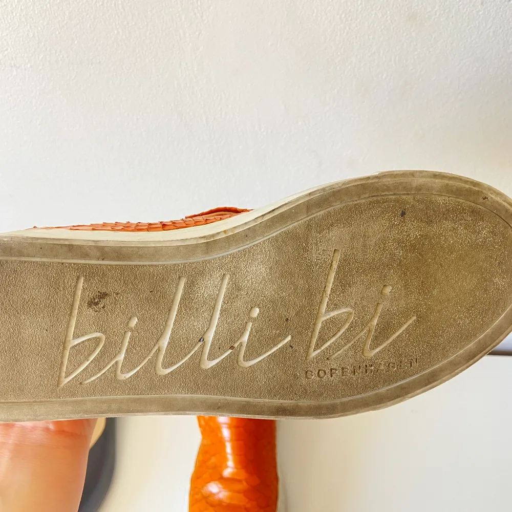 Slip ons från Billi Bi. Organgea med krokodilskinns mönstrat äkta läder. Använda några gånger och därav är den vita kanten runt om skon smutsig, annars i topp skick. . Skor.