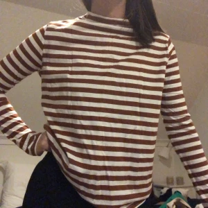 Weekday långärmad tröja  - Supersnygg långärmad brun/vit randig tröja från weekday! Tröjan har högre krage med båtringning och dragkedja där bak i nacken. Använd några gånger men har noga tecken på slitage. Köparen står för frakten💕 priset kan oftas diskuteras och kan även ge paketpris så kika gärna in de andra jag säljer