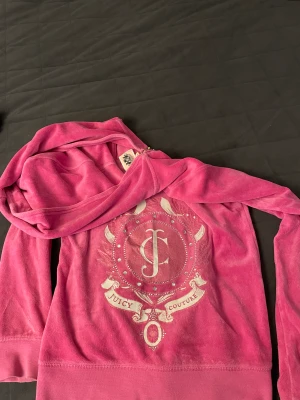 Juicy Couture tröja - Rosa juicy couture tröja med vitt tryck på ryggen, använd men fortfarande mjuk och skön och i fint skick! Säljer då den inte kommer till användning längre💖