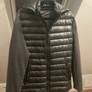 Massimo Dutti jacka - En hybrid jacka, perfekt skick, strl L, färg mörkgrå/silver. Luvan går även att ta av. Kan både skickas med spårbart/vanligt, alternativt mötas upp. Vid snabb affär så står jag på frakten