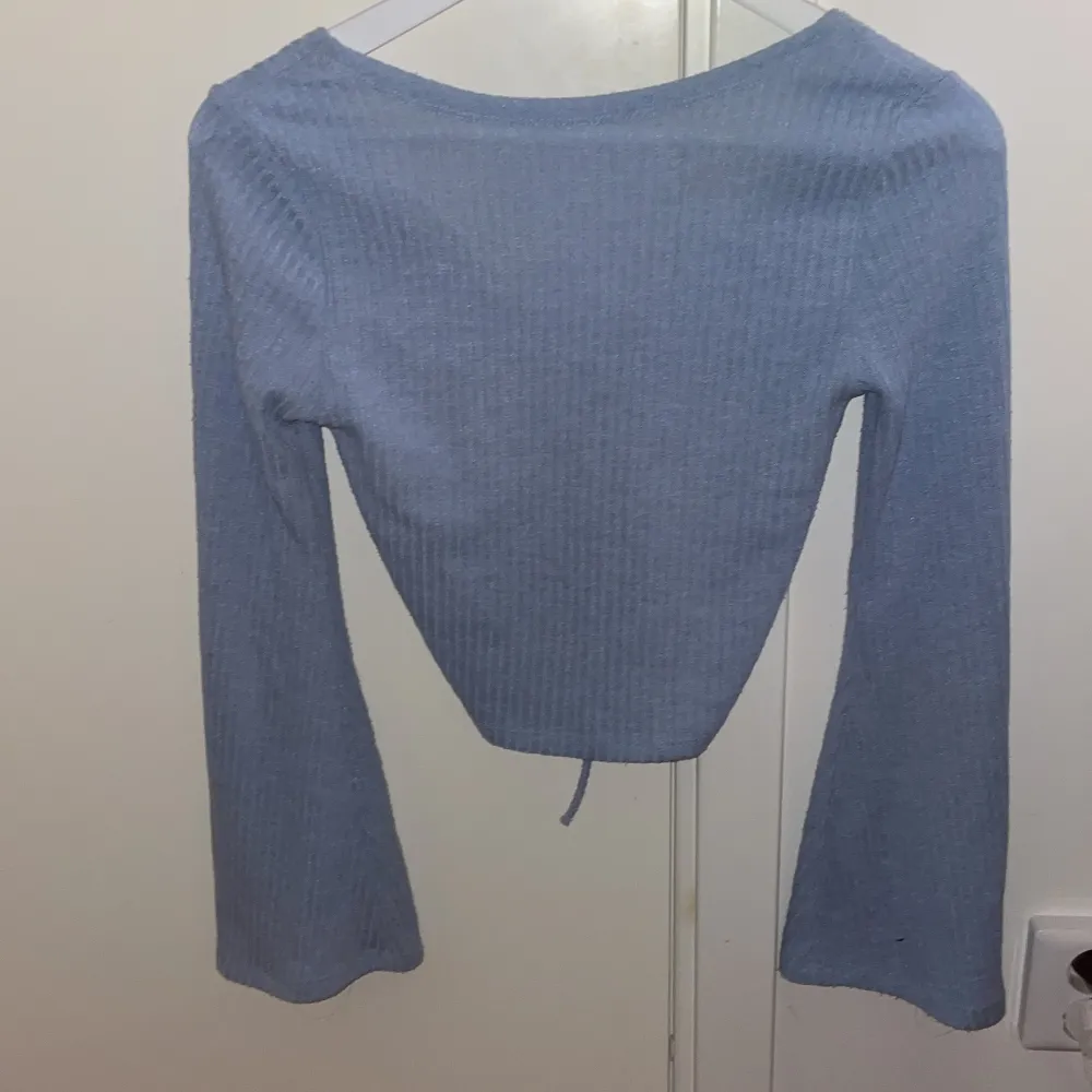en fin blå tröja med snörning, använts av mig men inga tecken på defekter 🤝strl S köpt för 199kr säljer för 90 💞. Toppar.