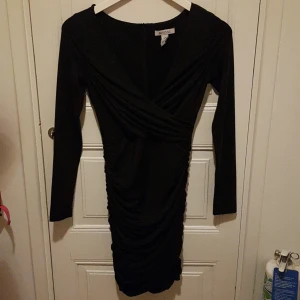 Snygg little black dress. Svart klänning NLY one - Snygg klänning med scrunch bak. Dragkedja bak. Från Nly. XS. Omlott fram. Något tjockare tyg. Mycket fint skick.