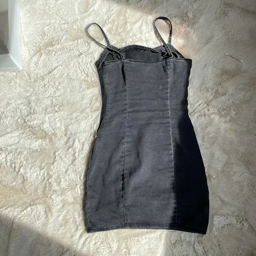 En tajt mörkgrå/svart klänning från hm i strl 36, ganska tunnt och stretchigt material. Klänningar.