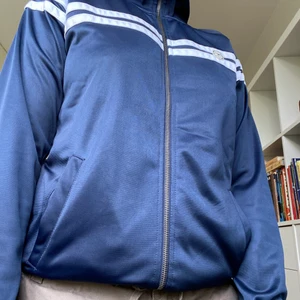Track jacket mörkblå - Mörkblå track jacka i nylon ish. Kan passa allt från s-L. Använt mycket och passar till det mesta, skön som tröja. Köpare står för frakt