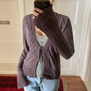 Fin mysig kofta - Jättemjuk och skön kofta i bomull med virkade detaljer och tunt knytband 🥰 Färgen är en mörk korsning mellan grå och lila. Bra skick och kvalitet