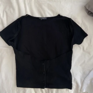 Backless svart t-shirt topp - Säljer denna Brandy Melville t-shirt som jag har DIY till en backless t-shirt.  Om du har övriga frågor eller vill ha fler bilder är det bara att hmu! Köparen står för frakt och betalning med swish. 3 FÖR 2 PÅ ALLA TOPPAR/SKJORTOR - kolla in min profil!
