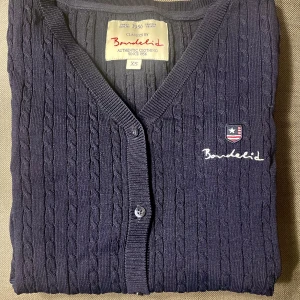 Marinblå kofta från Bondelid  - Oanvänd marinblå kabelstickad kofta från Bondelid. 