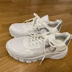 Vita sneakers med grå detalj. Använda ett fåtal gånger. Några märken som syns på bilderna.