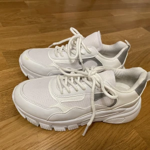Vita sneakers  - Vita sneakers med grå detalj. Använda ett fåtal gånger. Några märken som syns på bilderna.