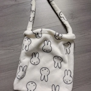 Väska - En söt axelväska med kaniner. I bra skick knappt använd. Själva väskan är 31cm • 28cm. Axelbandet är 72cm